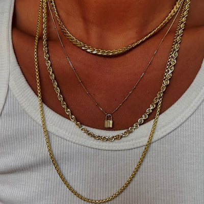 A model wearing a Miami Cuban, Rope, Round Box, and Beaded Essential Chains with a Lock Charm