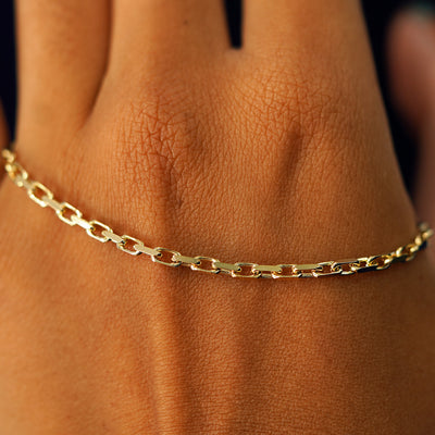 A solid gold Anchor Chain resting on the back of a model's hand