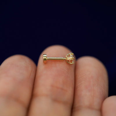 Side view of a yellow gold Diamond Flatback Piercing on a model's fingertips