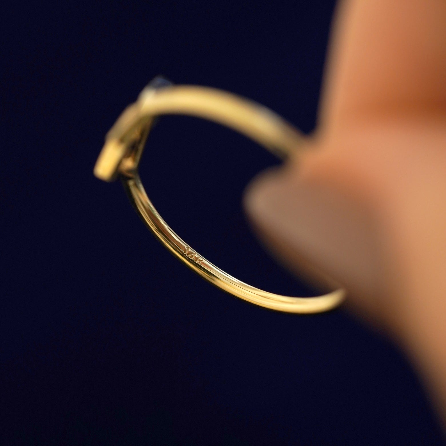 Underside view of a solid 14k gold geometric heart Ring to show the stamp