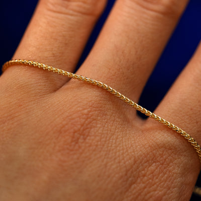 A yellow gold Mini Franco Chain Necklace on the back of a model's hand to show the details of the links