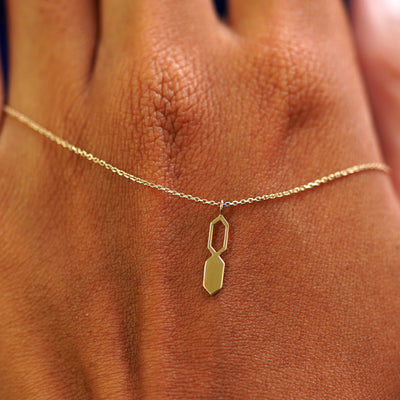 A solid gold Tanlah Cable Necklace resting on the back of a model's hand
