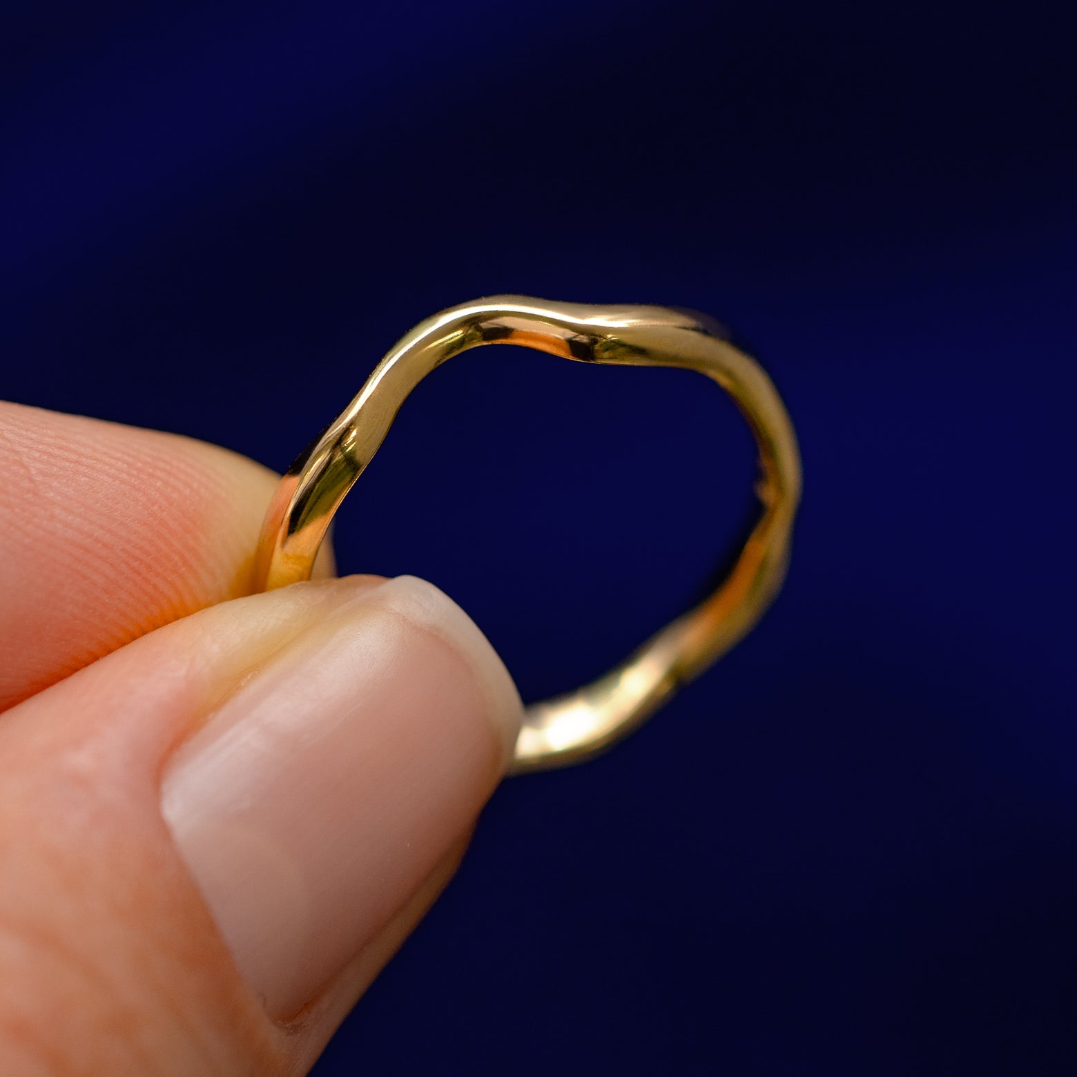 A model holding a Thin Liquid Band tilted to show the side of the band