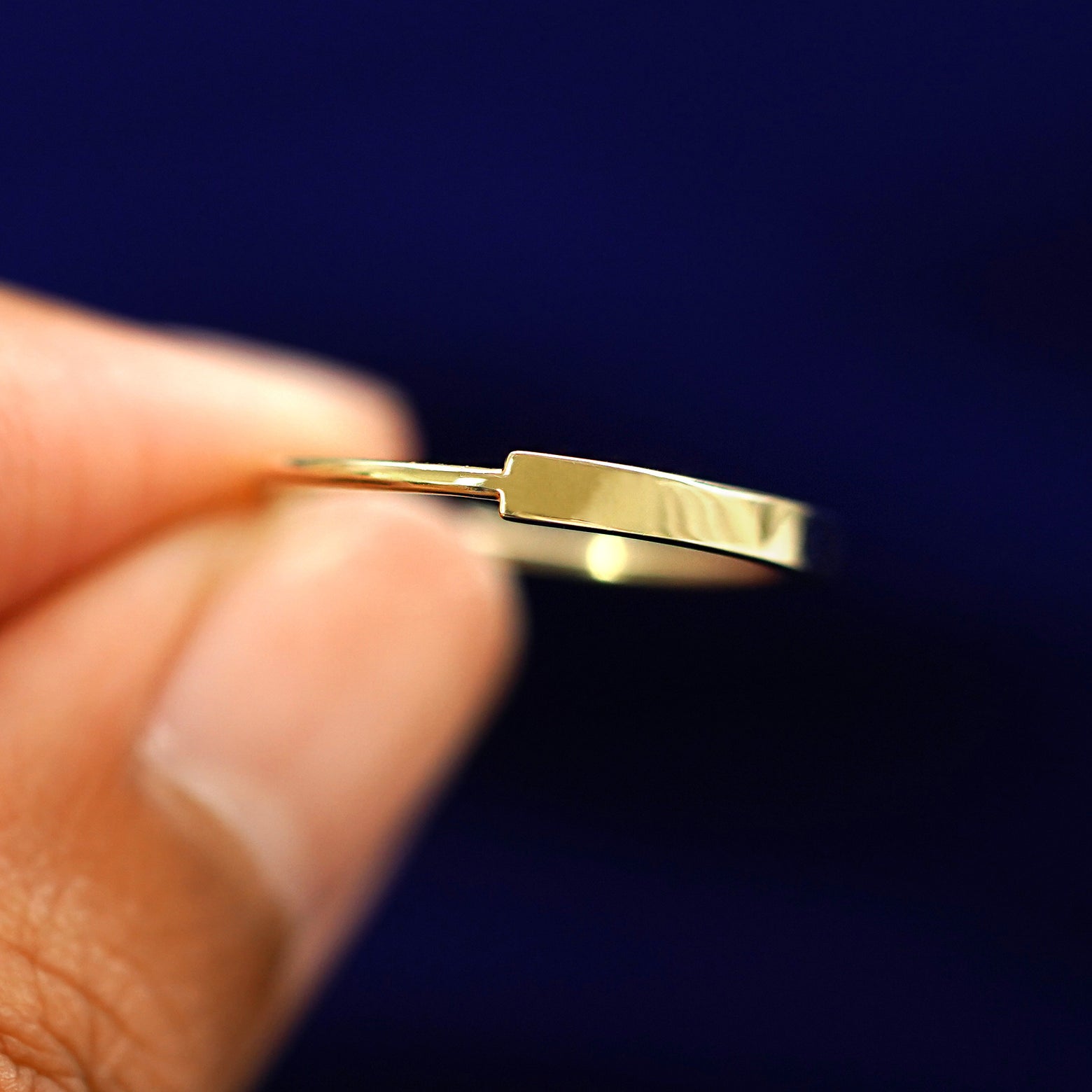 A model holding a Bar Ring between their fingers to show detail