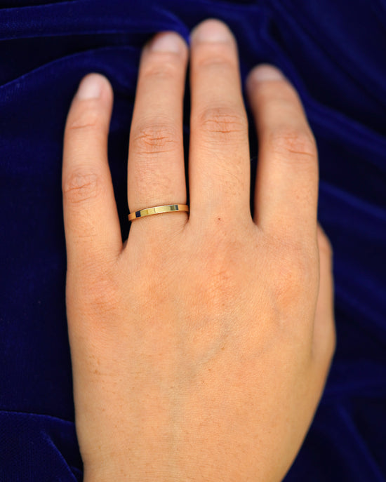 A hand wearing a 2mm band in size 4