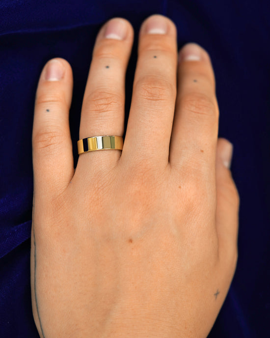 A hand wearing a 6mm band in size 6.5