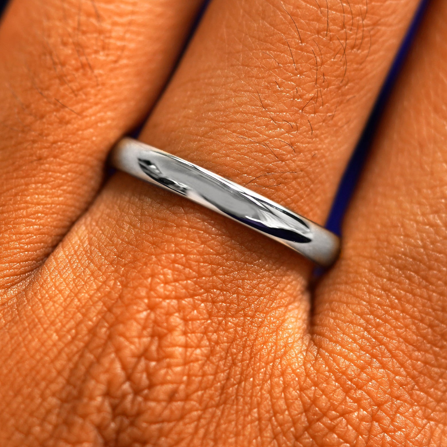 Close up view of a model's fingers wearing a 2mm 950 platinum Curvy Mirror Band