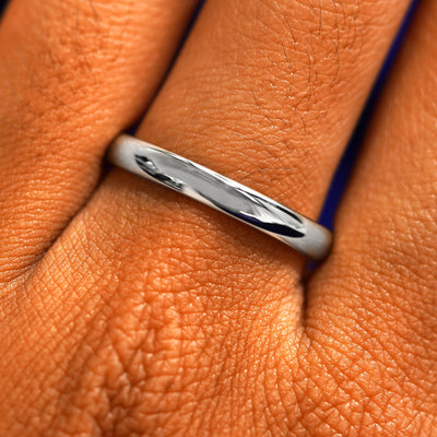 Close up view of a model's fingers wearing a 2mm 950 platinum Curvy Mirror Band