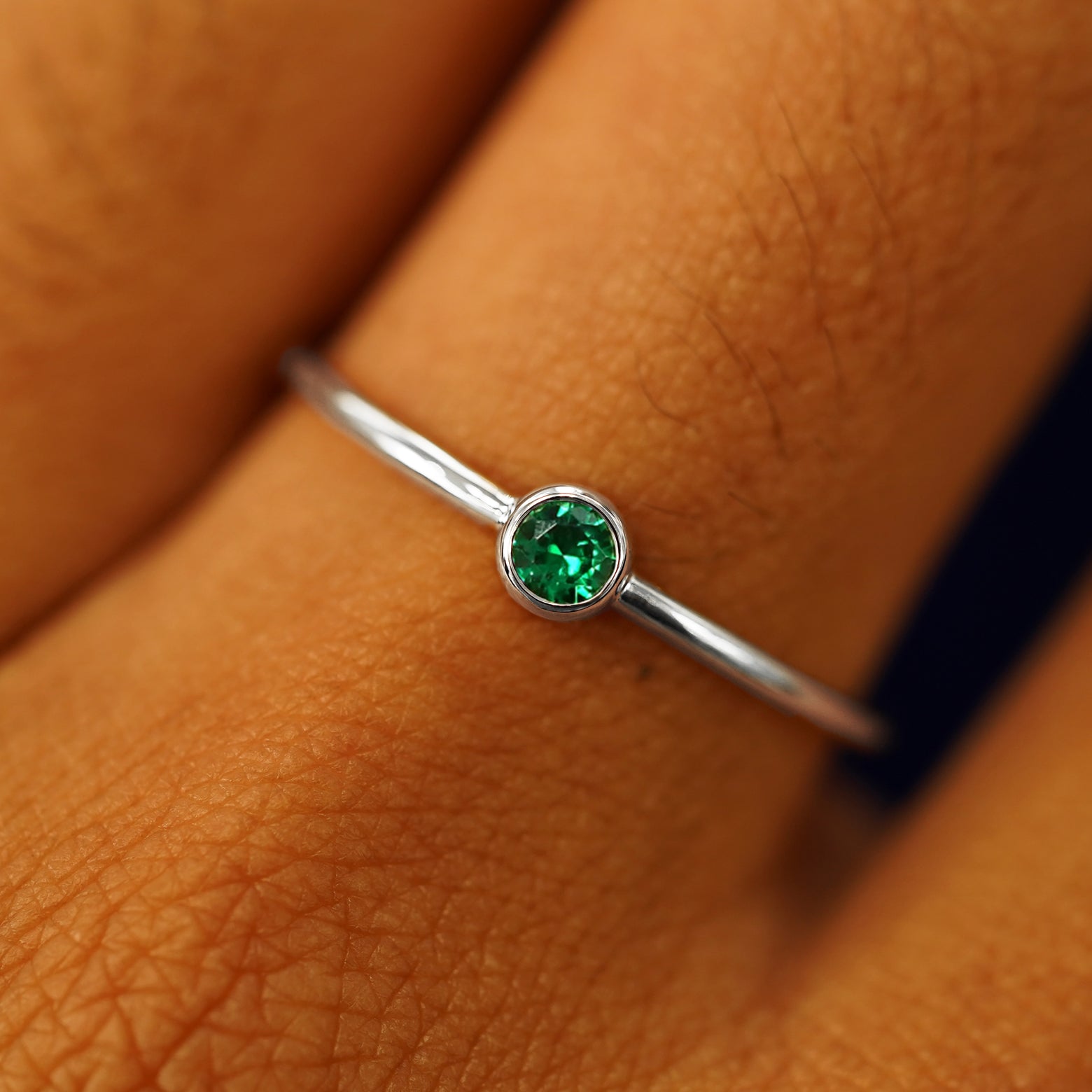 Close up view of a model's fingers wearing a 950 platinum Emerald Ring