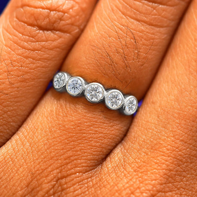 Close up view of a model's fingers wearing a 950 platinum Five Diamond Ring with clear diamonds