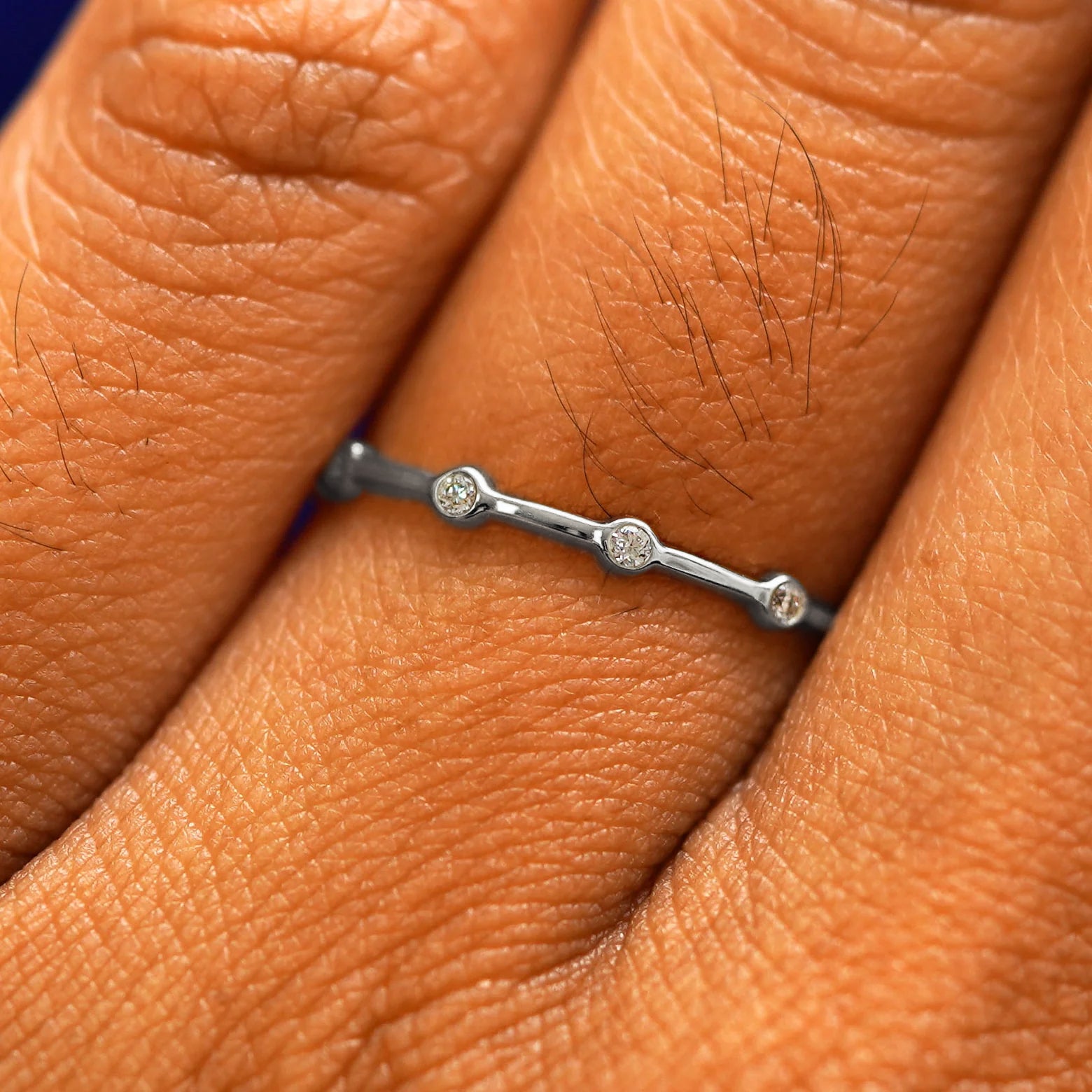 Close up view of a model's fingers wearing a 950 platinum Spaced Infinity Ring