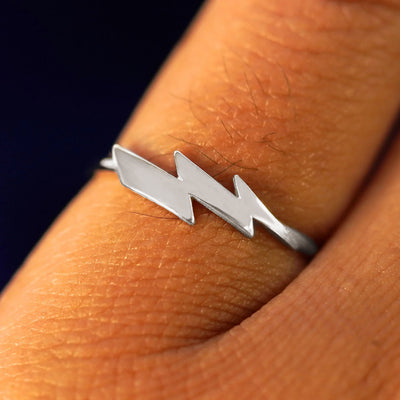 Close up view of a model's hand wearing a platinum Lightning Bolt Ring