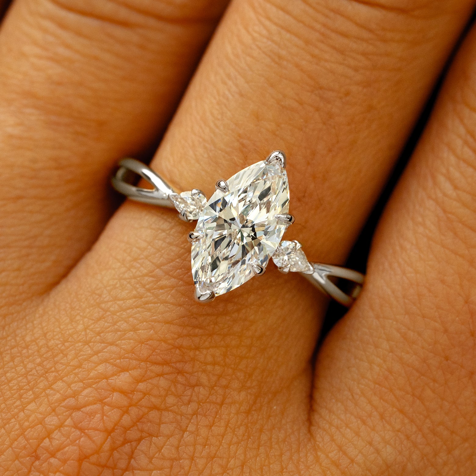 A solid 950 platinum Marquise Lab Diamond Three Stone Ring on a model's finger