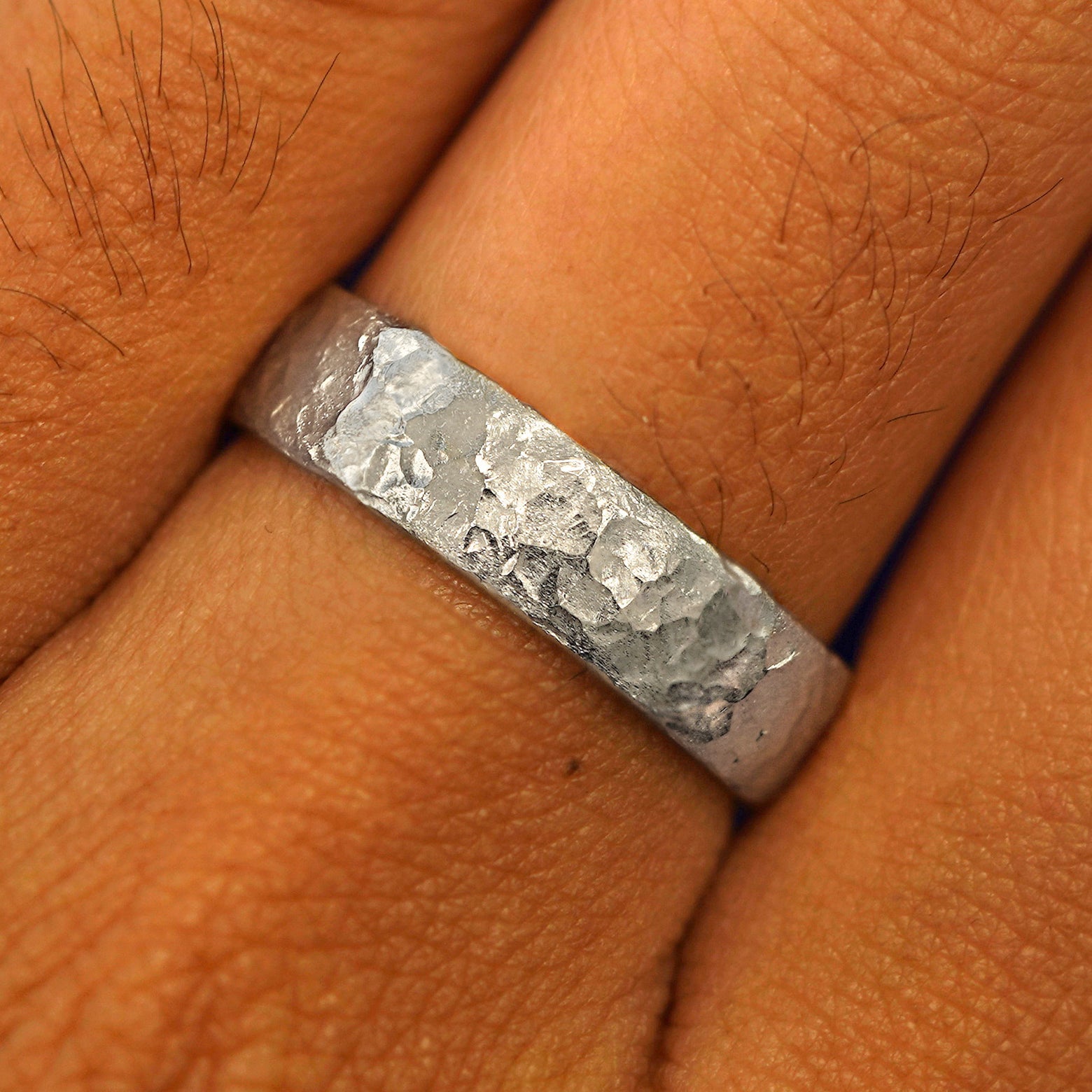 Close up view of a model's fingers wearing a platinum Mix Organic Band