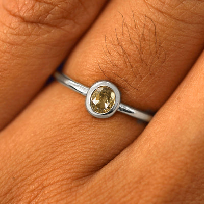 Close up view of a model's fingers wearing a 950 platinum Oval Champagne Diamond Ring
