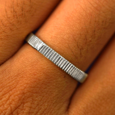 Close up view of a model's fingers wearing a 950 Platinum Edge Band