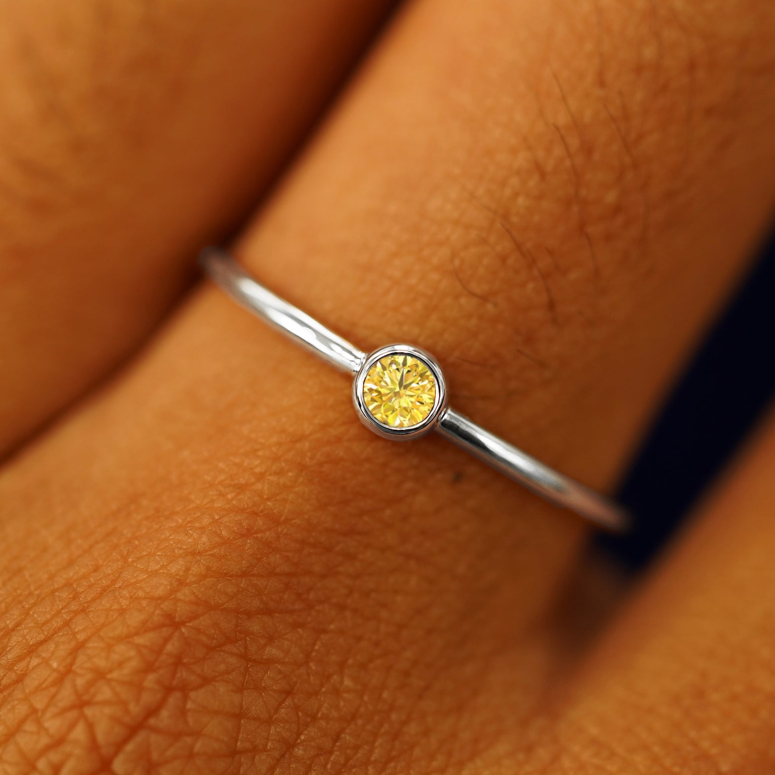 Close up view of a model's fingers wearing a 950 platinum Yellow Diamond Ring