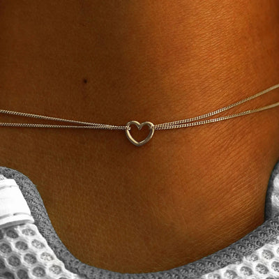 Close up view of a model's ankle wearing a 14k champagne gold Heart Anklet