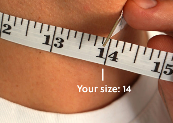 A model using a soft tape measure on their neck to show they need a 14 inch choker necklace