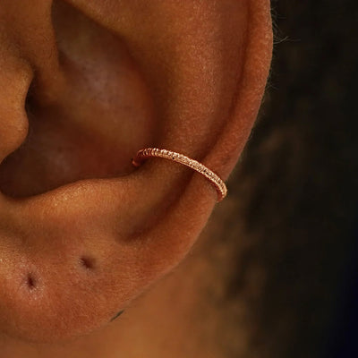 A model's ear wearing a 14k yellow gold Shimmer Line Cuff