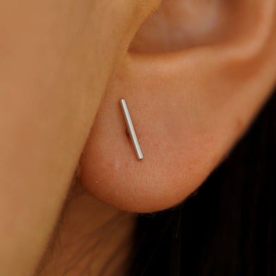 Close up view of a model's ear wearing a Large line Earring in White Gold.