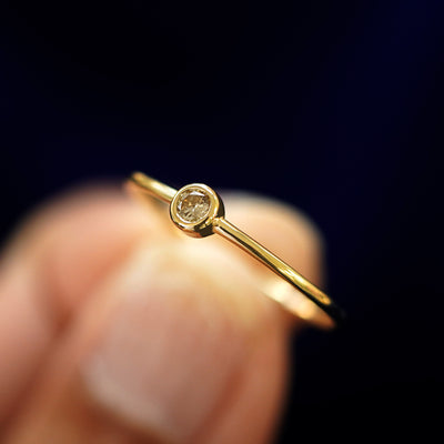 A model holding a Champagne Diamond Ring tilted to show the bezel setting
