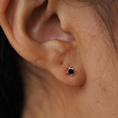 Close up view of a model's ear wearing a yellow gold Black Diamond Flat Back Earring