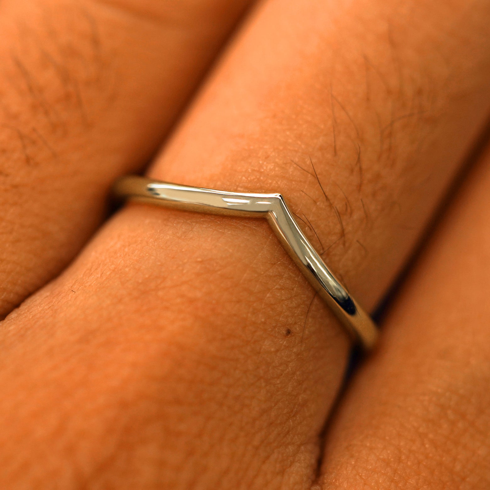 Close up view of a model's fingers wearing a 14k champagne gold Chevron Band