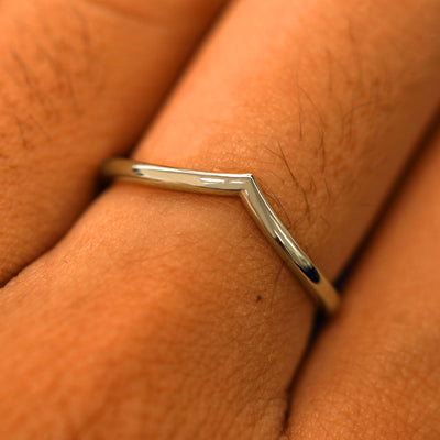Close up view of a model's fingers wearing a 14k champagne gold Chevron Band