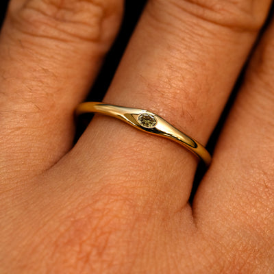 A 14k yellow gold Flush Set Oval Champagne Diamond Ring on a model's finger