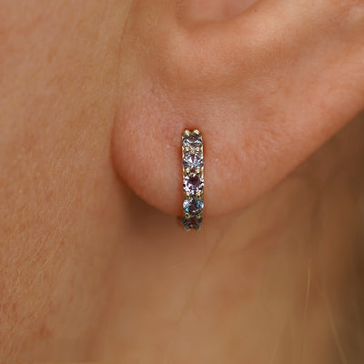 Close up view of a model's ear wearing a champagne gold Small Alexandrite Huggie Hoop