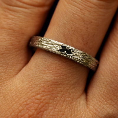 Close up view of a models fingers wearing a 14k champagne gold baguette diamond raw band