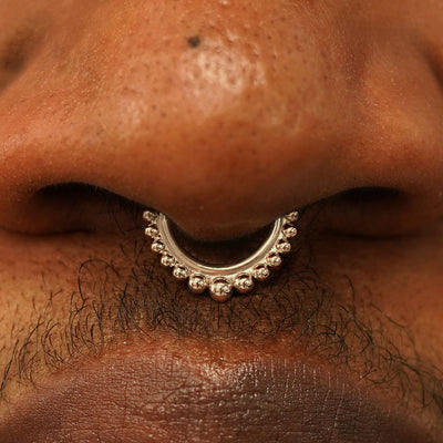 Close up view of a model's nose wearing a 14k champagne gold Beaded Septum