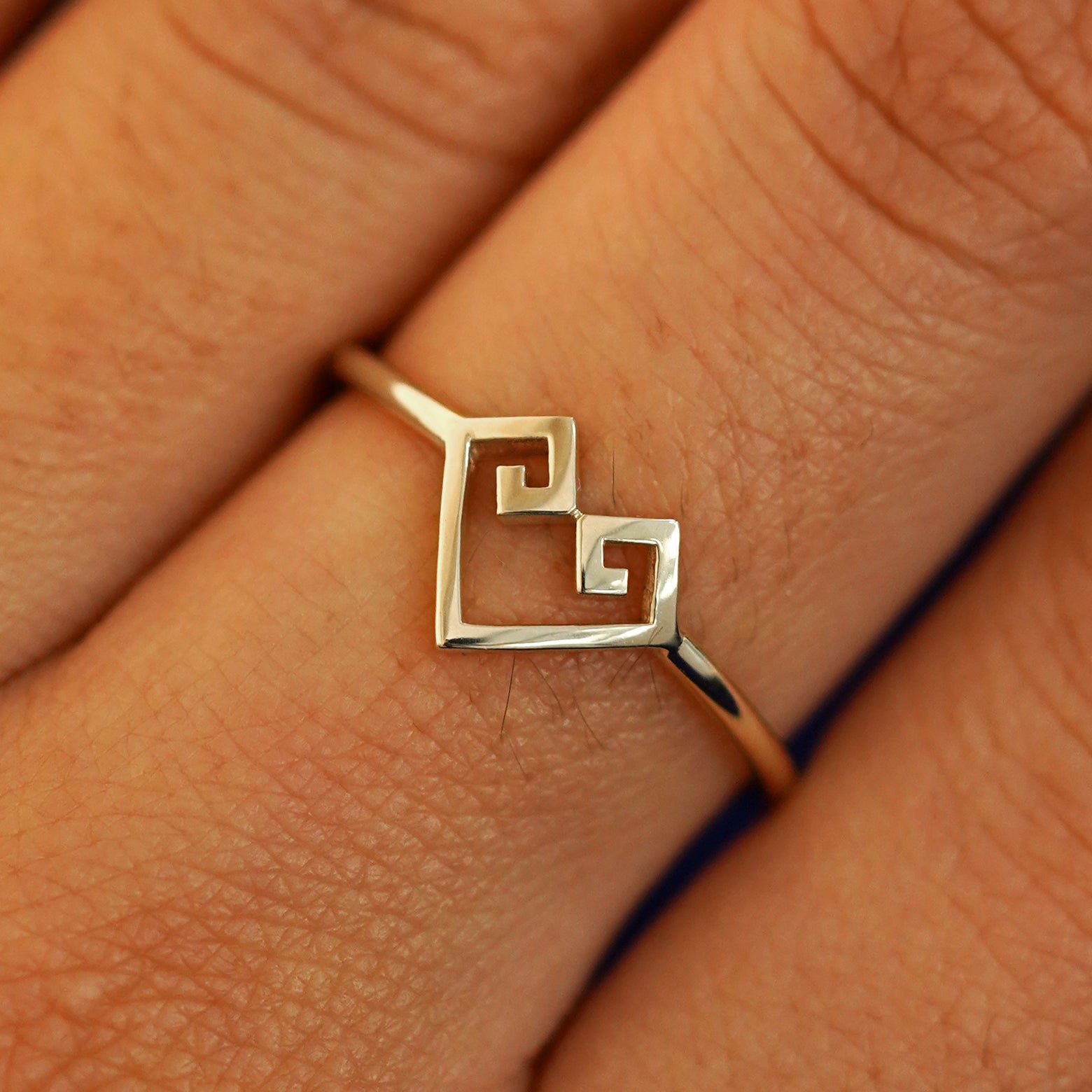 Close up view of a model's fingers wearing a 14k champagne gold Chere Heart Ring