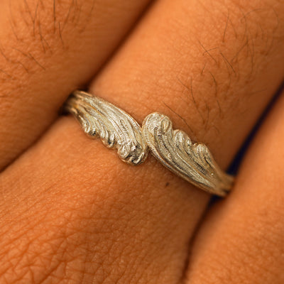 Close up view of a model's fingers wearing a 14k champagne gold Crashing Waves Band