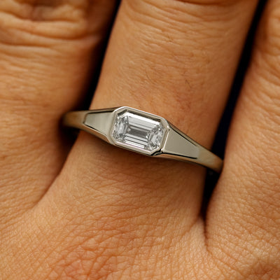 Close up view of a model's fingers wearing a 14k champagne gold Emerald Cut Lab Created Diamond Signet Ring