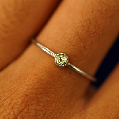 Close up view of a model's fingers wearing a 14k champagne gold Peridot Ring