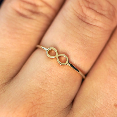 Close up view of a model's fingers wearing a 14k champagne gold Infinity Ring