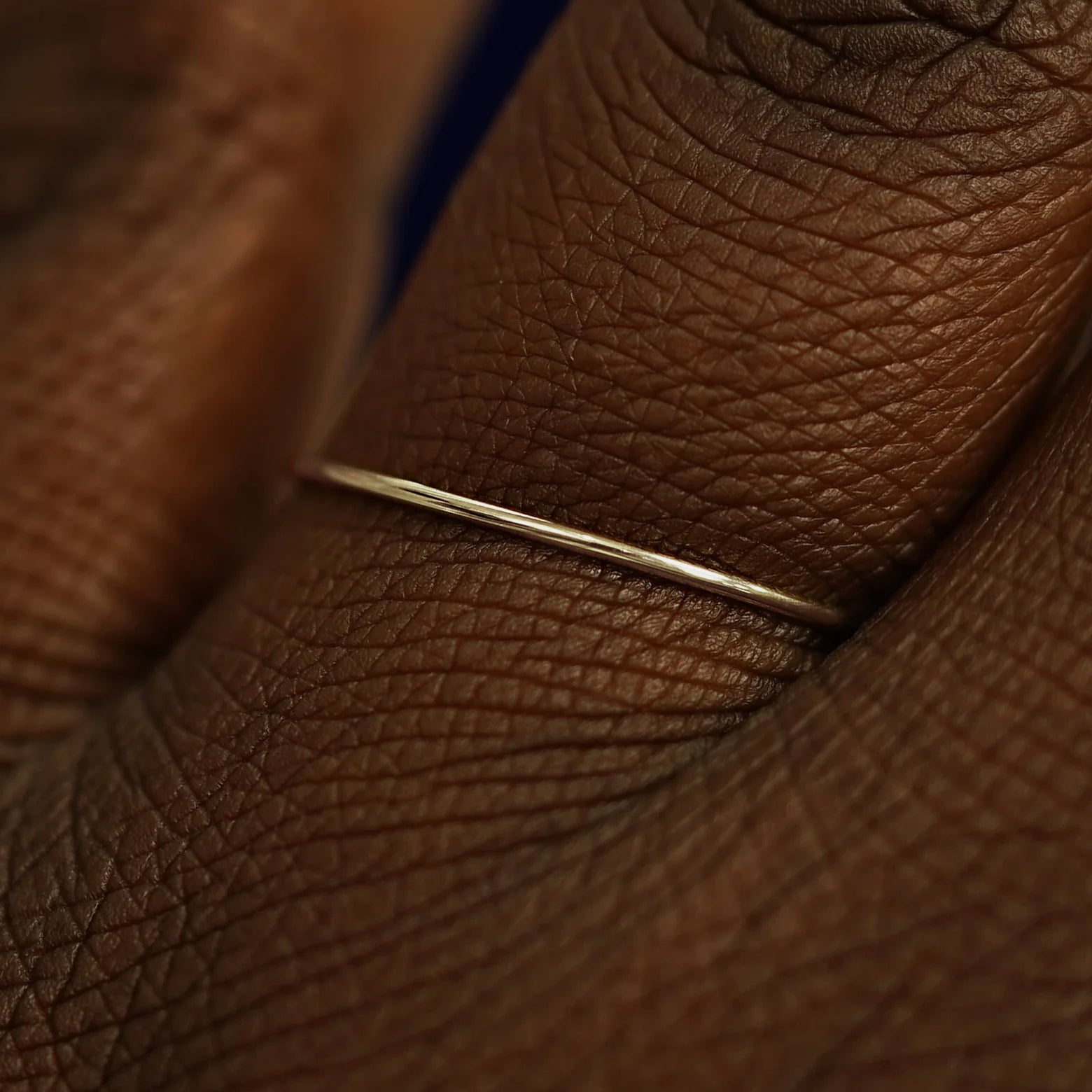 Close up view of a model's fingers wearing a 14k champagne gold Line Ring
