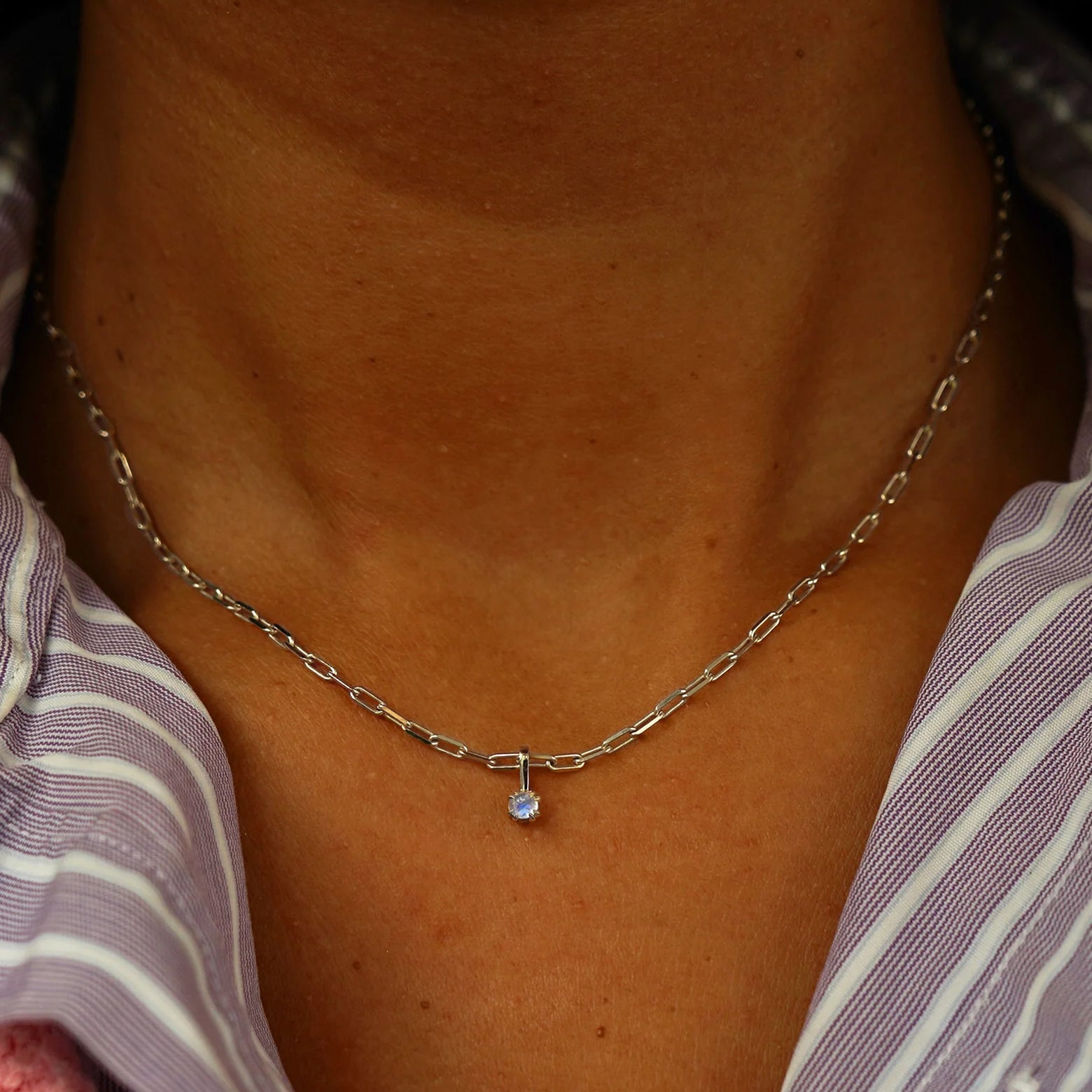 Close up view of a model's neck wearing a champagne gold Moonstone Charm on a Butch Chain
