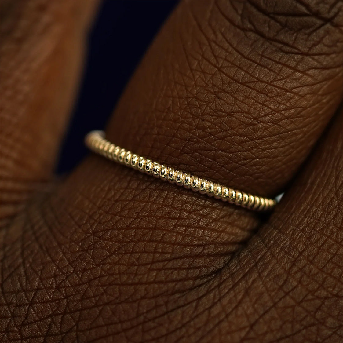 Close up view of a model's fingers wearing a 14k champagne gold Rope Ring