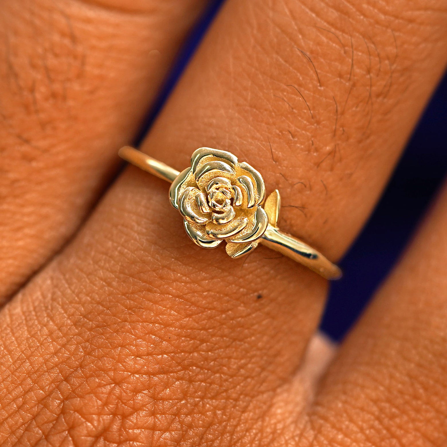 Close up view of a model's fingers wearing a 14k champagne gold Rose Ring