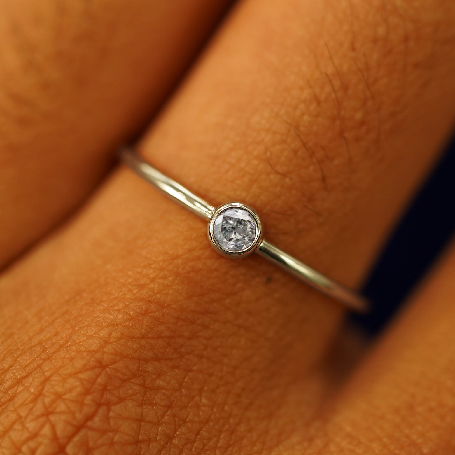 Close up view of a model's fingers wearing a 14k champagne gold Salt and Pepper Diamond Ring