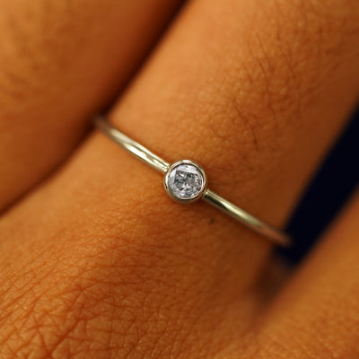 Close up view of a model's fingers wearing a 14k champagne gold Salt and Pepper Diamond Ring