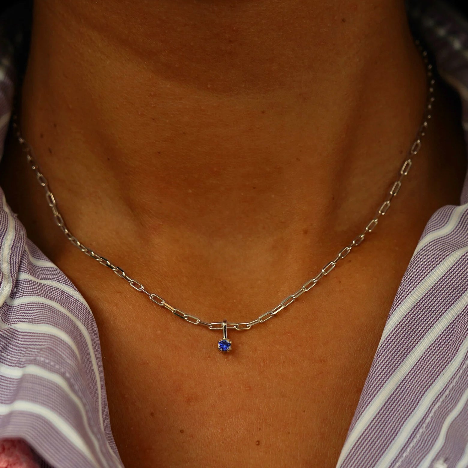 Close up view of a model's neck wearing a champagne gold sapphire Charm on a Butch Chain