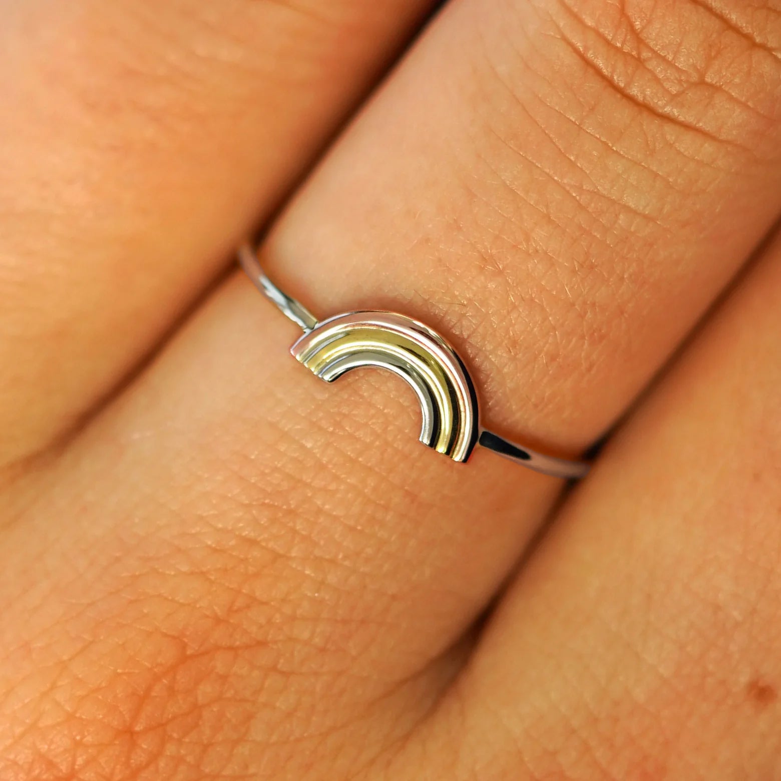 Close up view of a model's fingers wearing a solid champagne gold Rainbow Ring