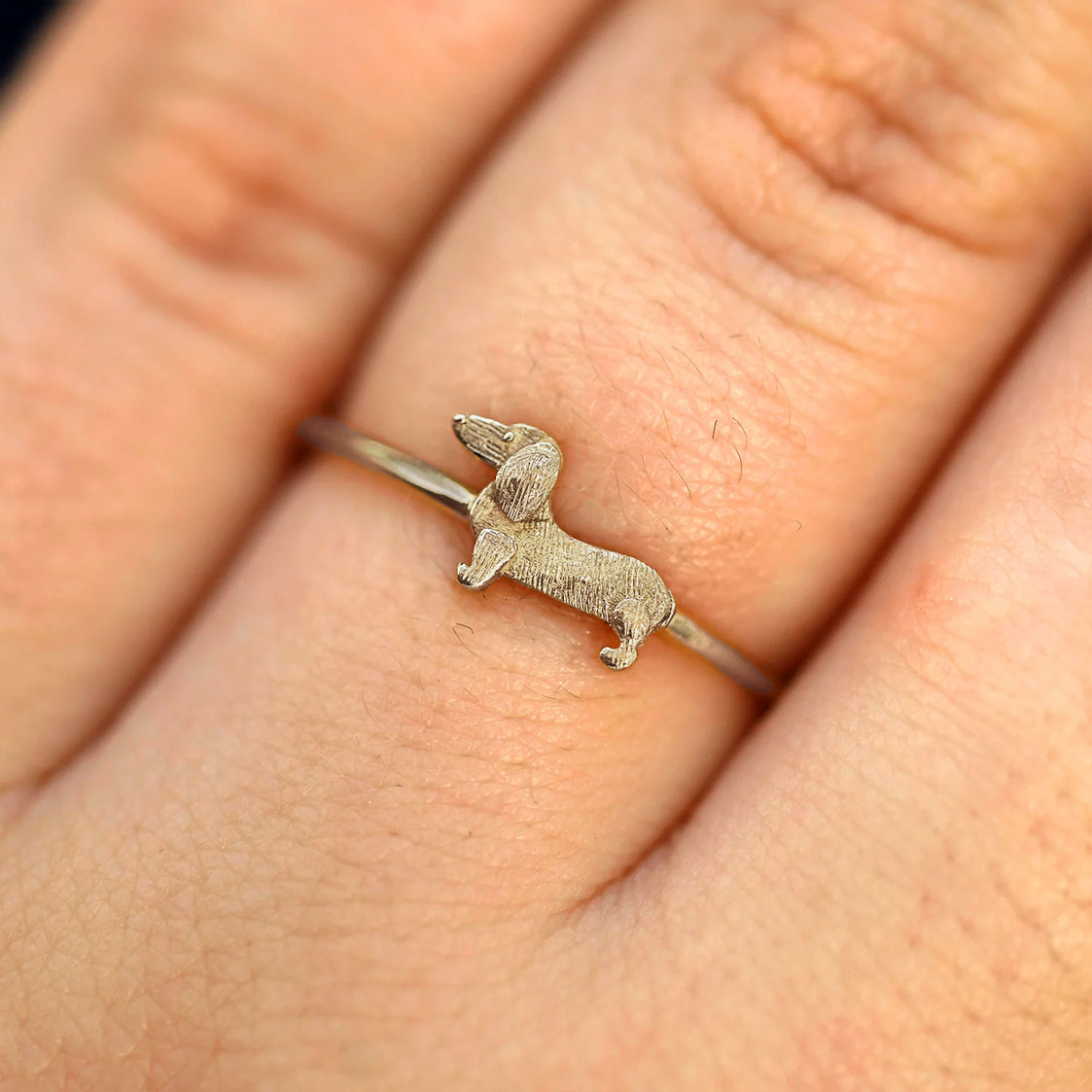 Close up view of a model's fingers wearing a 14k champagne gold Dog Ring
