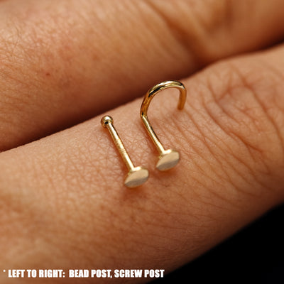 Close up view of a single two Circle Nose Studs with different backings resting on the back on a model's hand