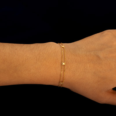 A model wearing a yellow gold double chain 8 pointed star bracelet