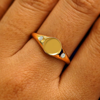 Close up view of a model's fingers wearing a 14k yellow gold Diamond Signet Ring